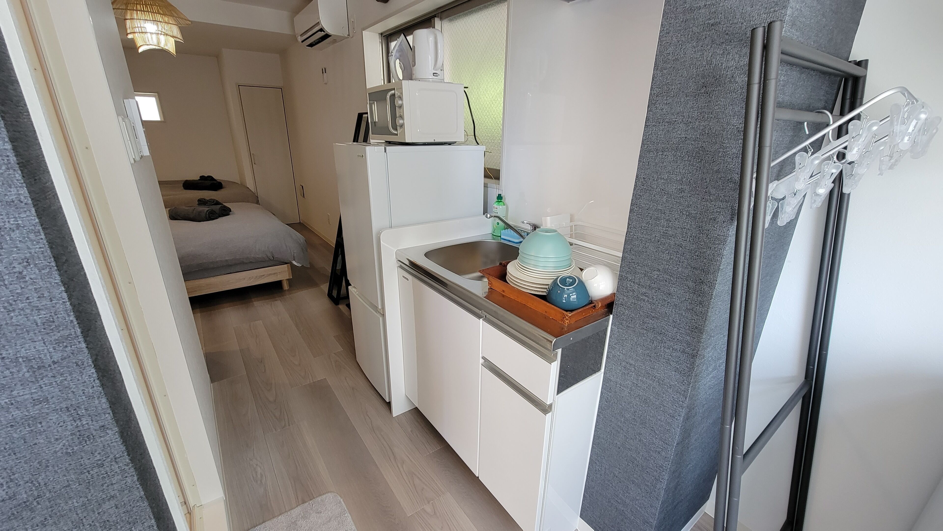 Eine kompakte Küchenzeile mit Spüle, Mikrowelle und kleinem Kühlschrank.