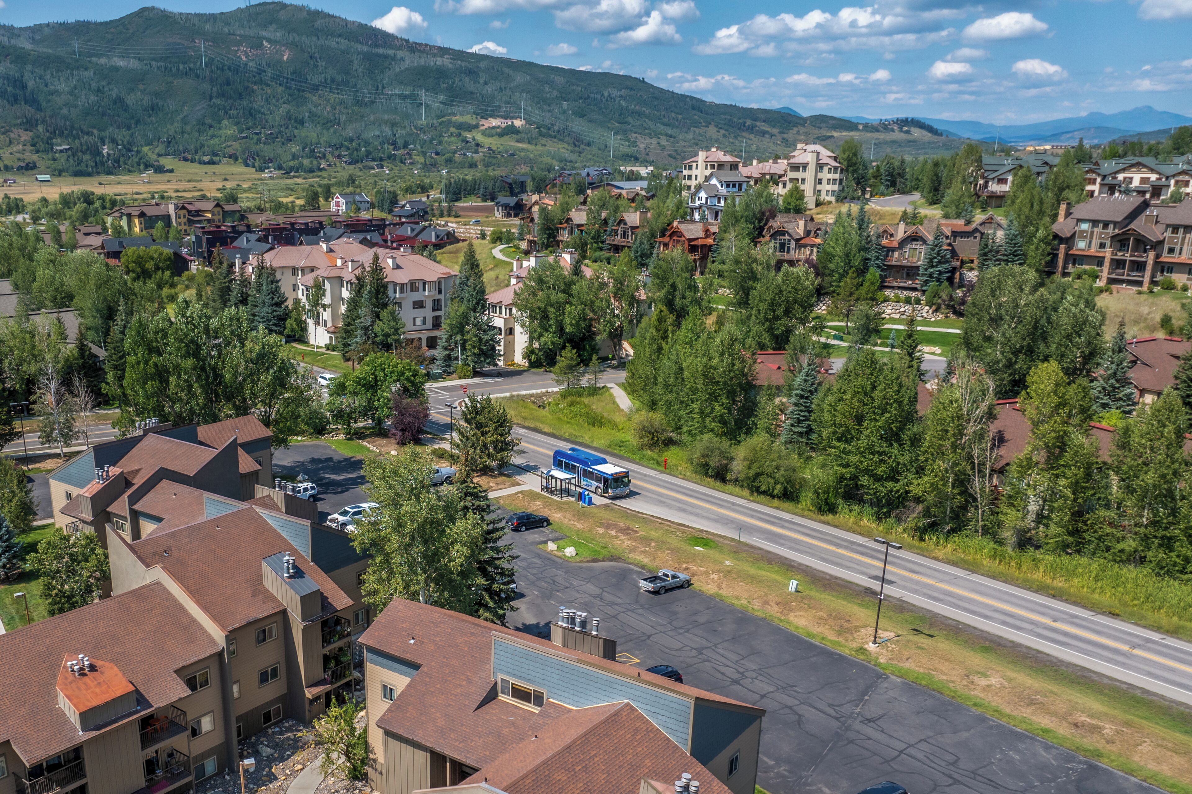 A residential area with multi-story buildings, a road, and a bus stop.