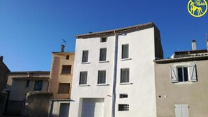 A multi-story building with a white facade and several windows. - Chez Makita - RdC (Mirepeisset)