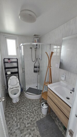 Chuveiro, secador de cabelo, toalhas de banho, sabonete