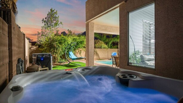 A hot tub with a view of a backyard, a pool, and a patio area. - Bella Bella!  Heated Pool/HotTub/Sauna/BBQ (Casa Grande)