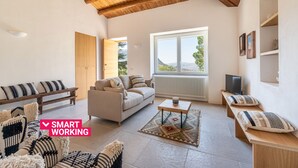 A spacious living area with a high wooden ceiling, a sofa, a coffee table, and a bench.