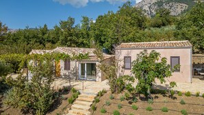 A rustic villa with a stone staircase leading to a glass door entrance, surrounded by lush greenery and a vineyard. - Borgo Le Niche by Wonderful Italy - Calliope (Polizzi Generosa)