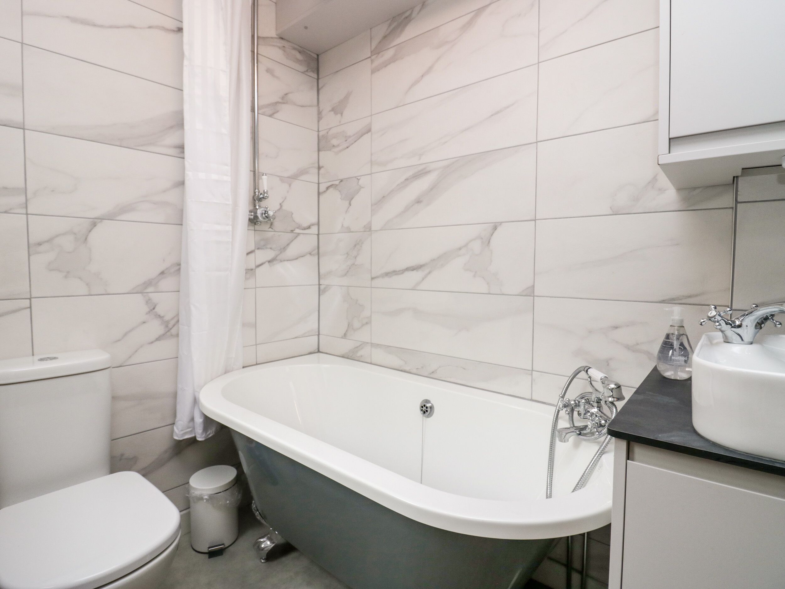 A bathroom with a clawfoot bathtub, a toilet, and a sink.