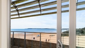 Ein Balkon mit Blick auf Strand und Meer.