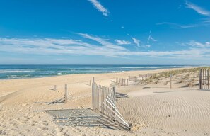 A sandy beach with a wooden fence and dunes. - Sunrise Sunset - Nags Head MP 20, 45 Yds to Beach, Ocean View, Hot Tub, Pool Table, Pets OK (Nags Head)