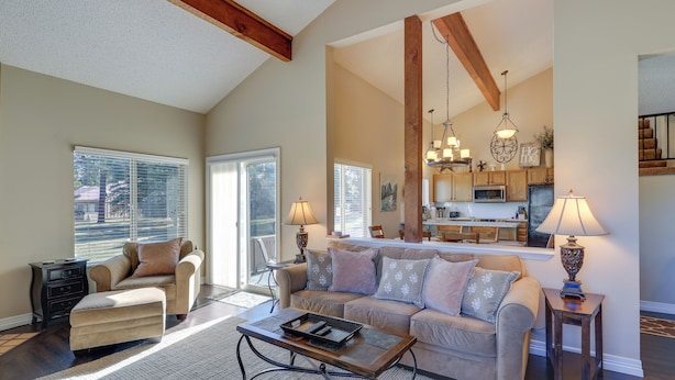 A spacious living room with a sofa, ottoman, and coffee table, a dining area with a table and chairs, and a kitchen in the background. - Dog-friendly Pagosa Springs Condo Near Hot Springs (Pagosa Springs)