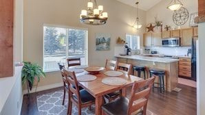 A spacious kitchen with wooden cabinets, a central island, and a dining area with a large table and chairs. - Dog-friendly Pagosa Springs Condo Near Hot Springs (Pagosa Springs)