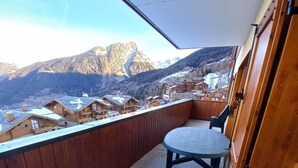 Un balcón con vista a montañas nevadas y edificios de madera.