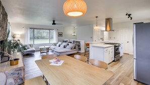 A modern kitchen with a central island, white cabinetry, and a stainless steel refrigerator. - Serene Palmer Home: Walk to Downtown & Riverfront! (Palmer)