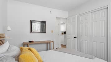 A bedroom with a bed, bedside table, and a wardrobe.