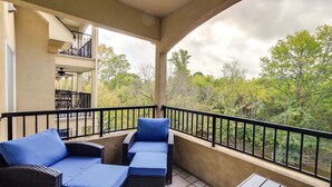 A covered balcony with wicker furniture and a view of a forested area. - Sevierville Vacation Rental: 6 Mi to Dollywood! (Sevierville)