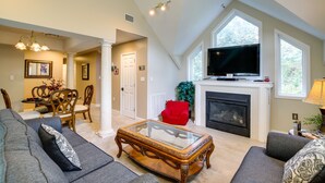 A spacious living room with a fireplace, a television, and a dining area with a table and chairs. - Sevierville Vacation Rental: 6 Mi to Dollywood! (Sevierville)