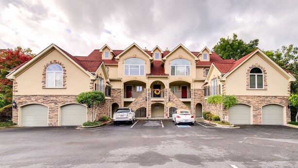 A multi-story building with a symmetrical facade, featuring a central entrance with a decorative archway and two parking spaces in front. - Sevierville Vacation Rental: 6 Mi to Dollywood! (Sevierville)