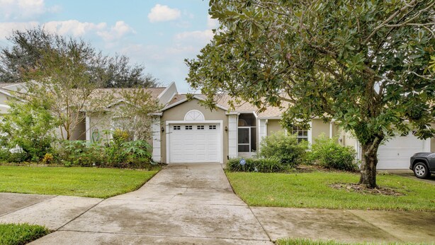 A residential house with a garage, a driveway, and a lawn. - 20 Mi to Disney: Condo w/ Pool Access in Clermont! (Clermont)