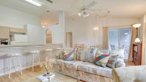 A modern living room with a sofa, chairs, a coffee table, and a kitchen area. - 20 Mi to Disney: Condo w/ Pool Access in Clermont! (Clermont)