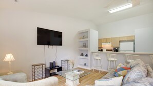 A modern living room with a flat-screen TV, a glass coffee table, and a sofa. - 20 Mi to Disney: Condo w/ Pool Access in Clermont! (Clermont)