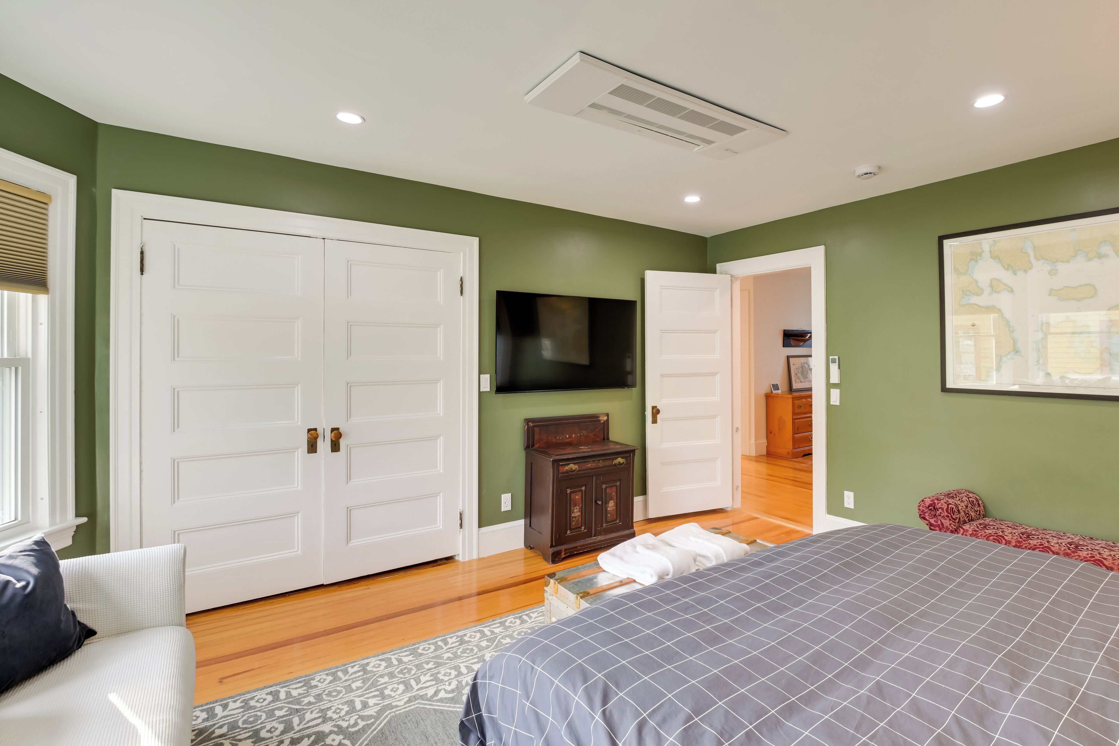 A bedroom with a bed, a dresser, a TV, and a wardrobe.