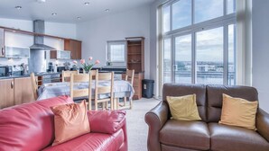 Un apartamento moderno con cocina, comedor y un amplio ventanal con vistas a la ciudad.