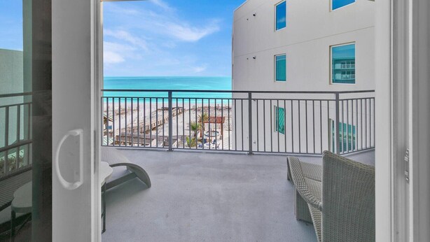 Ein Balkon mit Blick auf Strand und Meer.
