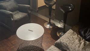 A compact living space with a kitchenette, a dining area with a round table, and a sofa.