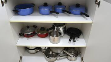 A kitchen cabinet with pots and pans.