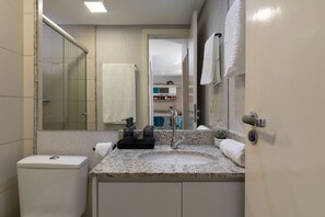 Un baño con inodoro, lavamanos y ducha.