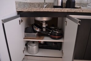 A kitchen with a granite countertop, a stainless steel sink, and a built-in oven. - UNIQUE RESIDENCE (Goiania)