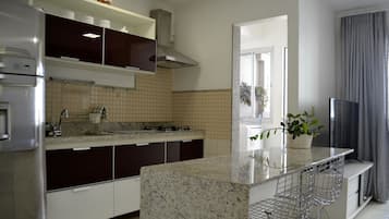 A modern kitchen with a central island, stainless steel appliances, and a dining area with bar stools.