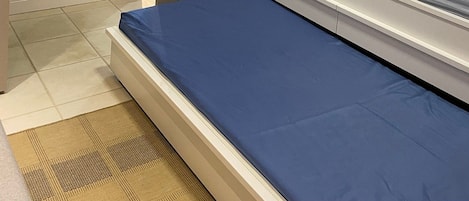 Un dormitorio con cama, armario y una ventana pequeña.