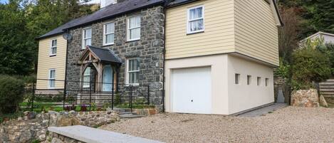 A two-story house with a stone facade and a beige exterior.