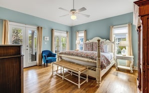 A bedroom with a bed, a chair, a bench, a nightstand, and a dresser.