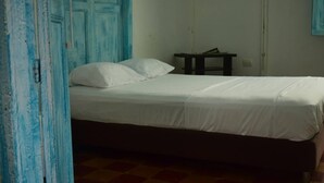 Un dormitorio con una cama, una mesita de noche y una puerta azul.