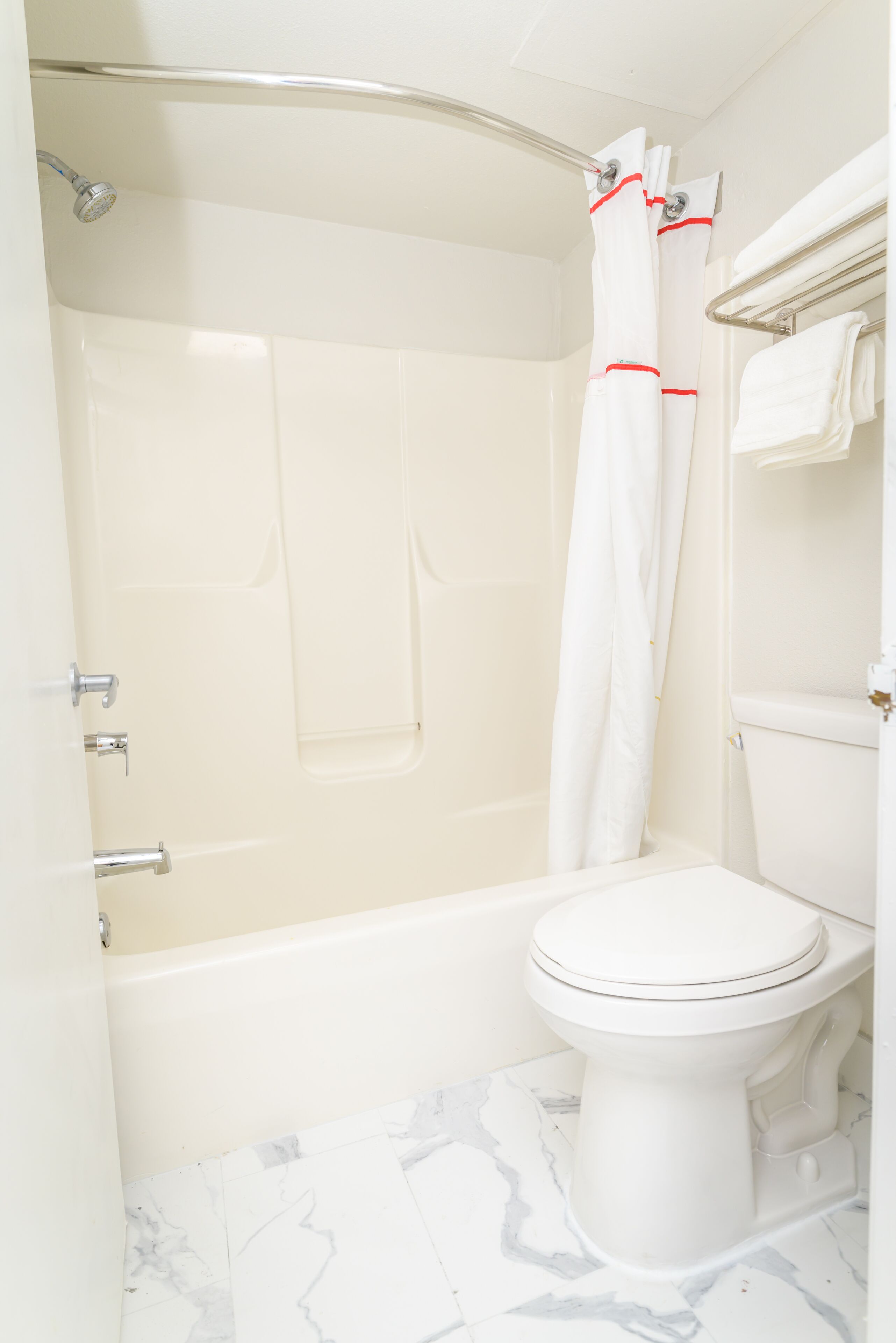 A bathroom with a bathtub, shower, and toilet.