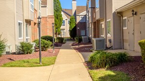 Une rue résidentielle bordée de maisons des deux côtés, avec un trottoir et quelques aménagements paysagers.