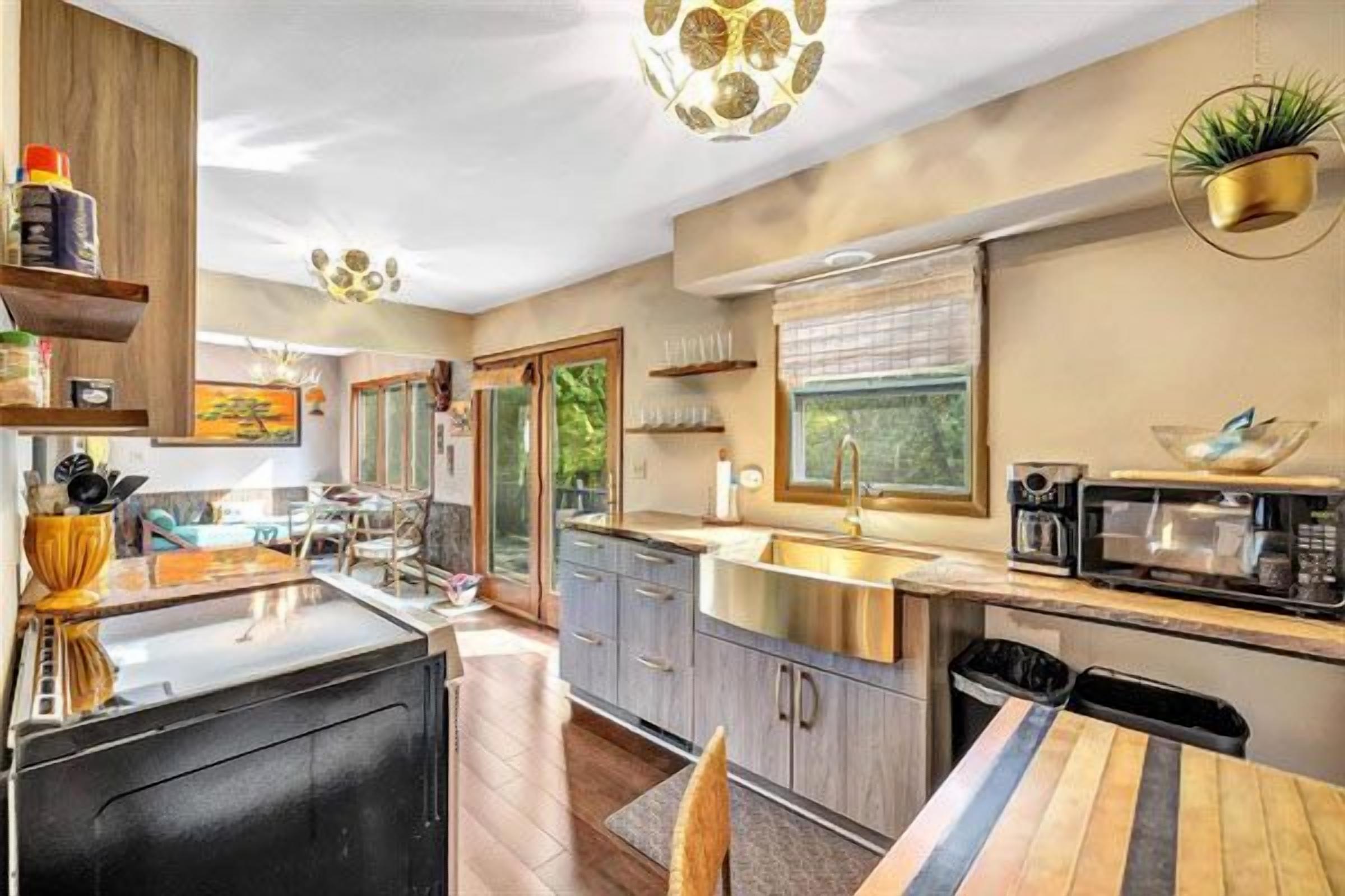 A modern kitchen with a central island, built-in appliances, and a view of the outdoors.