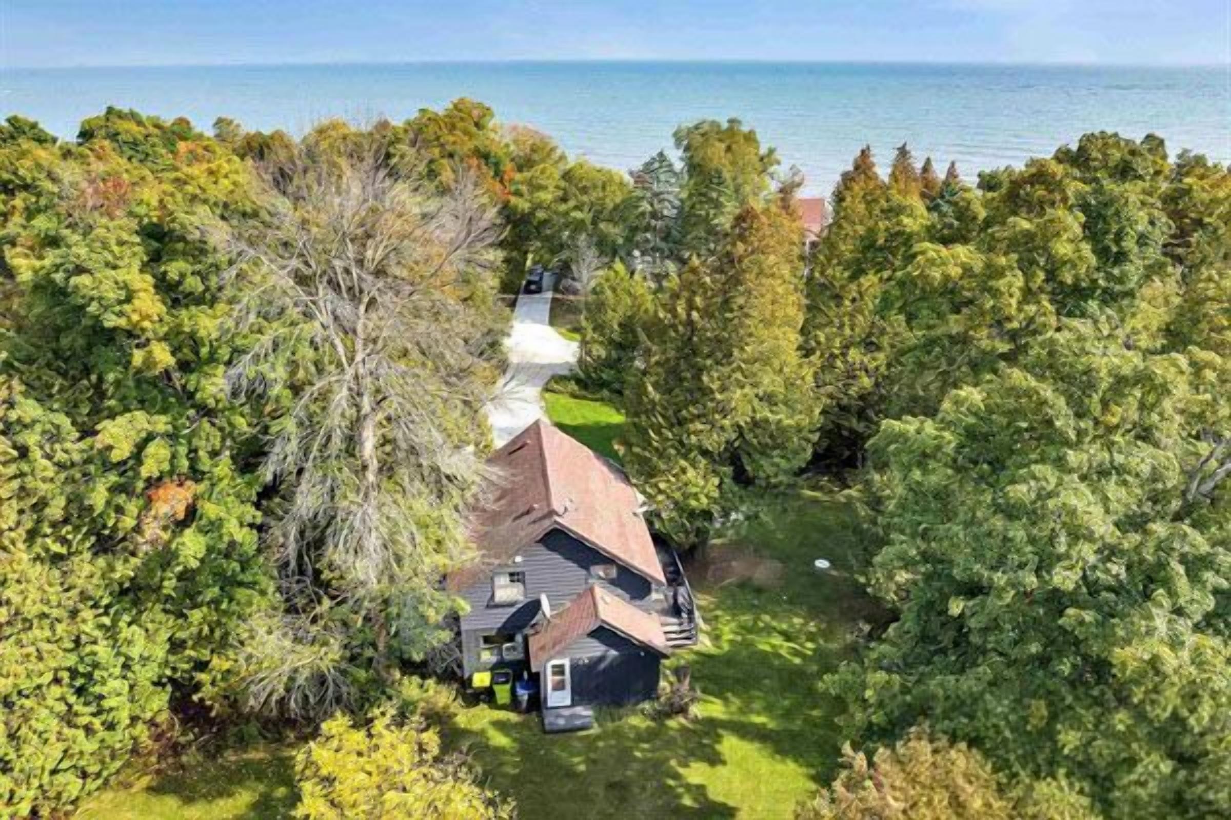 A house surrounded by trees with a view of the water.
