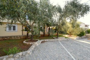 Stroll through the beautifully maintained outdoor space, surrounded by lush greenery and a charming walkway.