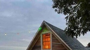 A small wooden cabin with a sloped roof, a front door, and a window. - The Sea Eagle - Luxury 5 BR Waterfront Home in Boothbay Harbor with Dock & Sauna (Boothbay Harbor)