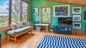 A cozy room with a wooden bench, a table, and a TV.