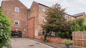 A brick building with multiple windows and a gated entrance. - 6 Granary Court (York)