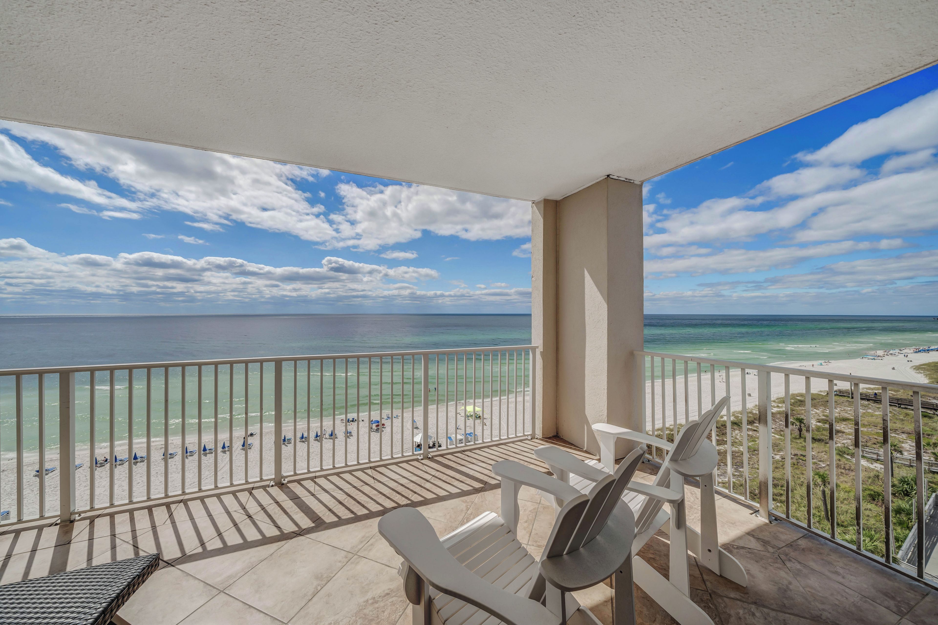 A balcony with a view of the beach and ocean.