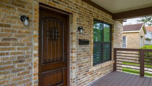 A brick exterior with a wooden door and a window, a mailbox, and a wooden deck. - 2BR Luxury EADO House! Medical Center, Stadiums ⭐️⭐️⭐️⭐️⭐️ (Houston)