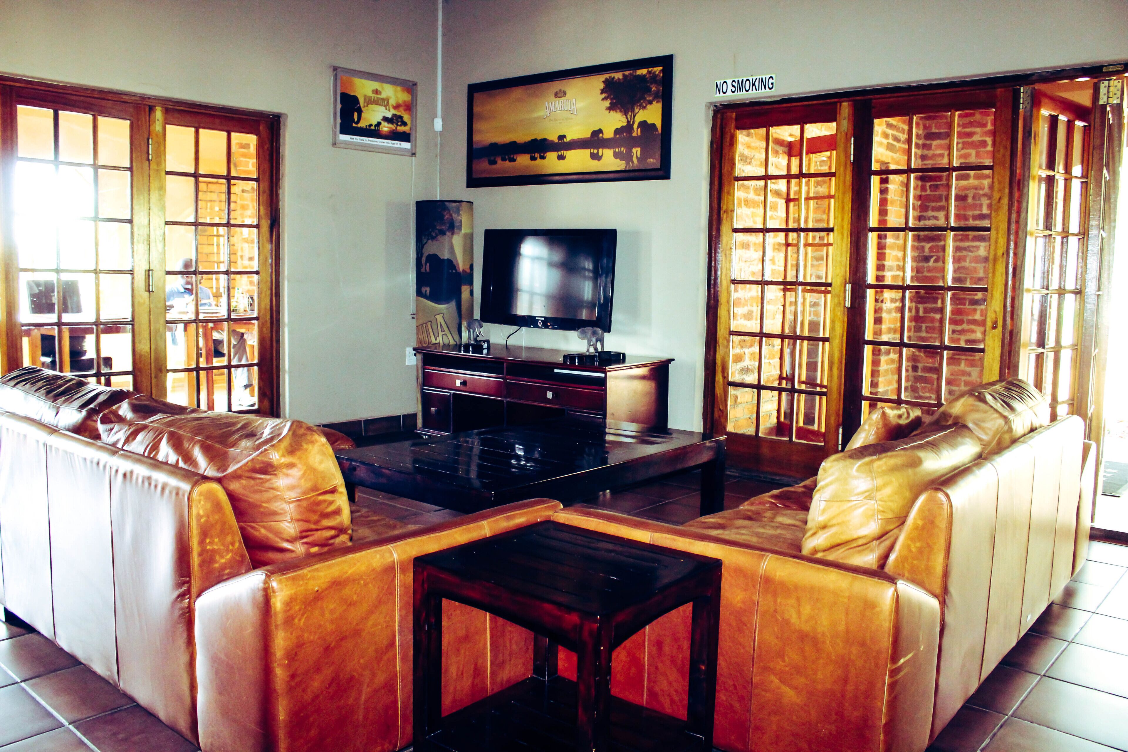 Una sala de estar con un sofá de cuero, una mesa de centro, un televisor y una chimenea.