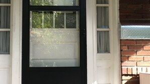 A black front door with a glass panel and a sign that reads "Please don't slam the door." - 850sq. ft basement apartment in quiet area of Rock Creek Park (Washington)