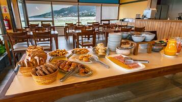 A buffet setup with various food items and a view of the outdoors.