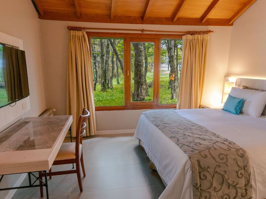 Um quarto com uma cama, uma escrivaninha e uma televisão.