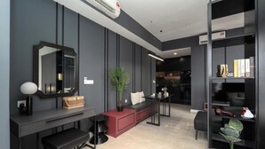 Een modern interieur met een donkere kleurenschema, een grote spiegel, een rode bank, een kleine tafel en een boekenkast.