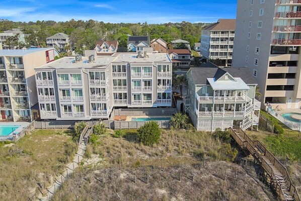 Un hôtel à plusieurs étages doté de balcons, d’une piscine et d’un accès direct à la plage.