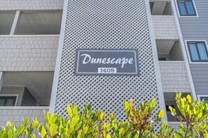 Un bâtiment dont la façade présente un mur texturé sur lequel est apposée une enseigne indiquant « Dunescape 1409 ».